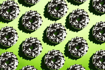 White donuts with black crumb on a green background