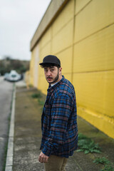 Chico atractivo joven con barba con ropa casual y camisa con skate