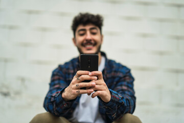 Fototapeta premium Chico atractivo joven con barba con ropa casual y camisa con skate
