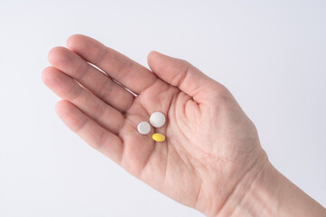 Female hand holding two pills.