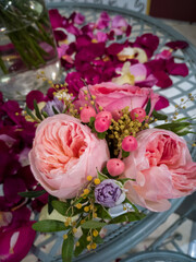 Composition from a small bouquet of roses and petals on the table
