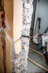 Brick wall drilling with a pneumatic hammer drill. A construction site.