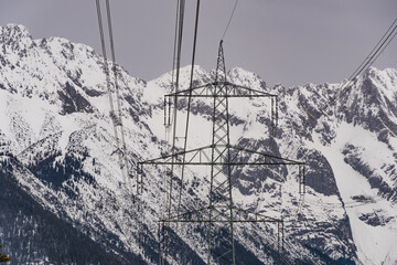Strommast vor schneebedeckten bergen