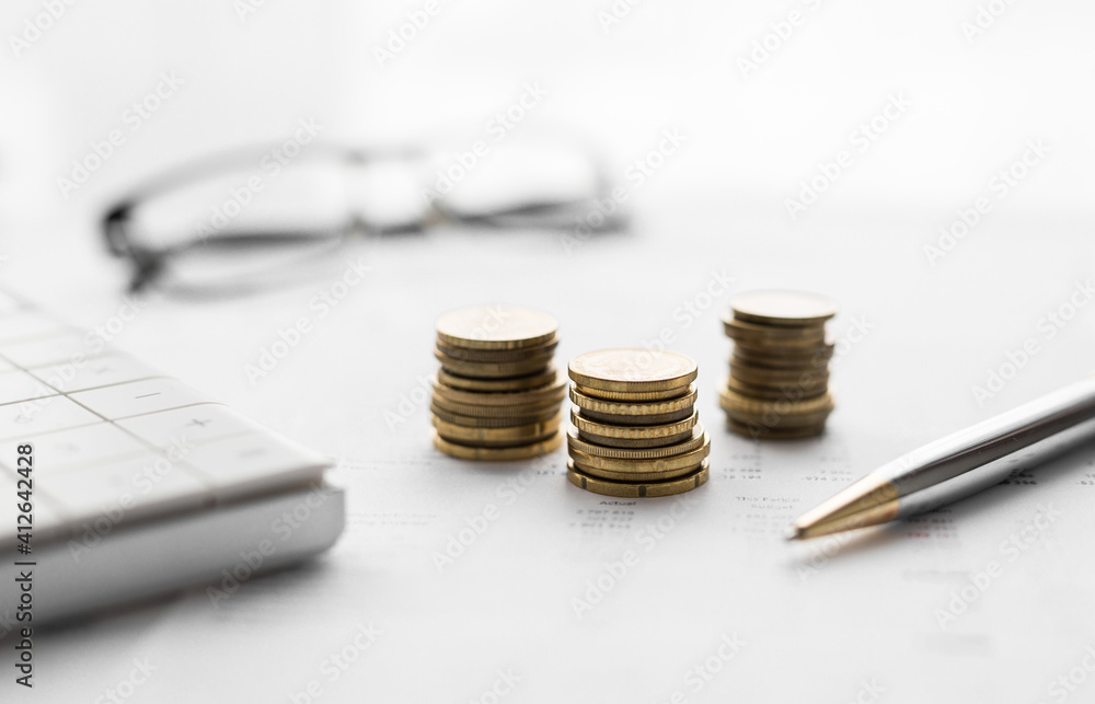 Poster close up of a calculator and coins on a financial data background