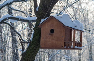 Wooden bird feeder in the winter forest.