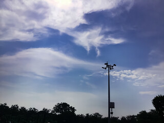 A light pole shot in the evening with cloudy blue sky in the background.