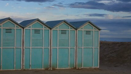 Blue beach sheds on the sand in a winter day (Pesaro, Italy, Europe)