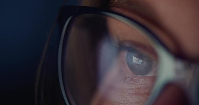 Woman with glasses watching movie - macro close up of eyeball with reflection of screen