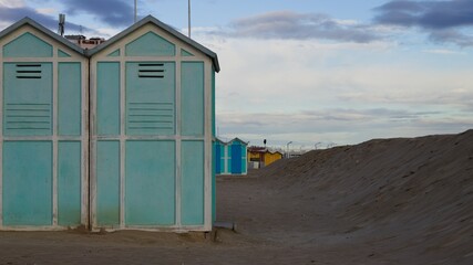 Blue beach sheds near a sand dune on the Mediterranean sea coast (Pesaro, Italy, Europe)