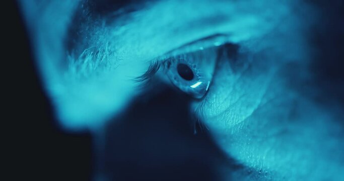 Macro close up of eye doused in blue light