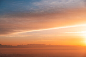 Naklejka na ściany i meble Beautiful panoramic bright sunset over the mountains silhouette.