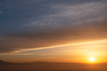 Beautiful panoramic bright sunset over the mountains silhouette.