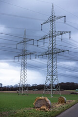 High voltage power lines in a rural area with nice, dark blue stormclouds taken at blue hour.