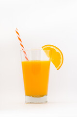 Orange juice in a glass with a slice of orange and an orange and white stew. 