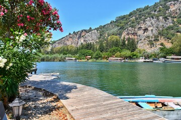 Turkey, Dalyan - June 2020: Beautiful view on Dalyan river with carved tomb on background, Turkey, Mugla. Turkish famous historical landmark. Lycian tombs