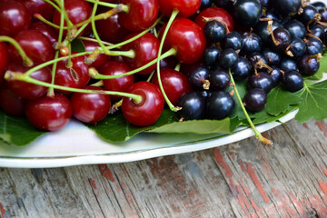 Berries organic harvest. Raspberry, black currant and cherry. Organic berries from village garden for jam, smoothie or desserts. Grunge wooden background.