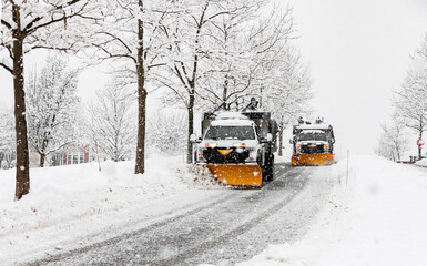 snow plowing machine in suburban neighborhood during northeastern storm nor'easter - Powered by Adobe