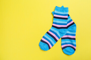 Top view of a pair of colored socks on a yellow background. Clothing in the form of socks.