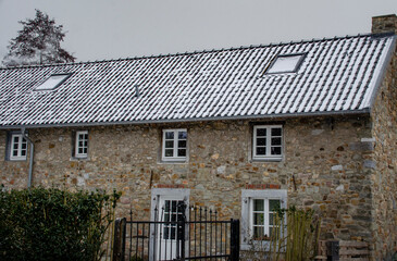 Ein Bruchsteinhaus mit Schnee auf dem Dach
