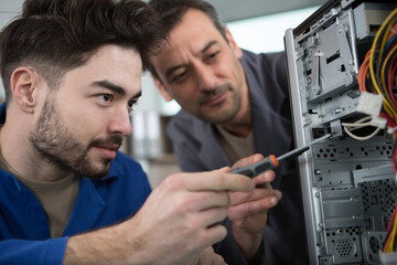 apprentice repairing computer in technical school