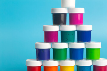 Acrylic paint of different colors on a blue background. Paint for painting