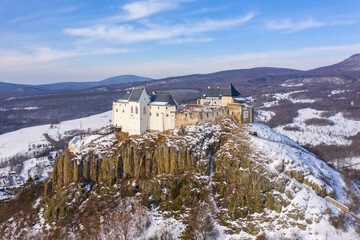 Füzér, Hungary - Aerial view of the famous castle of Fuzer built on a volcanic hill named Nagy-Milic. Zemplen mountains at the background. Winter landscape. Hungarian name is Füzér vára.