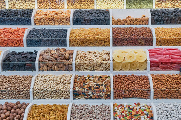 A counter with dried fruits and nuts at the bazaar of a resort town of the Caucasus or the Central...
