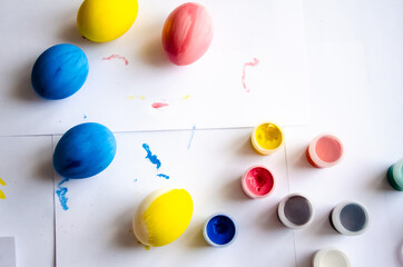 blue yellow pink eggs on white background at easter