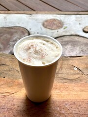 latte with cream in ceramic glass against natural background