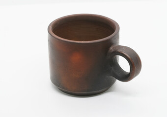 clay cup (mug) for milk or tea on a light background