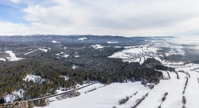 Bild einer Luftaufnahme mit einer Drohne der Ortschaft Riedelhütte im bayerischen Wald mit Bergen Arber Rachel und Lusen im Winter mit Schnee und Eis, Deutschland