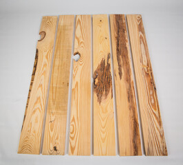 Unfinished raw pine lumber with light and dark color variation on a solid white background