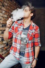Stylish man in a city. Elegant male use the electronic cigarette
