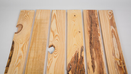 Unfinished raw pine lumber with light and dark color variation on a solid white background