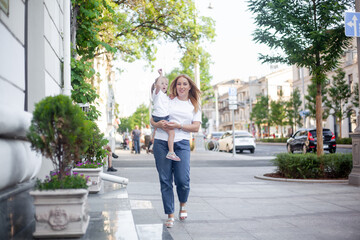 Mother and daughter walking outdoor in the street of the city, people spending time with family together