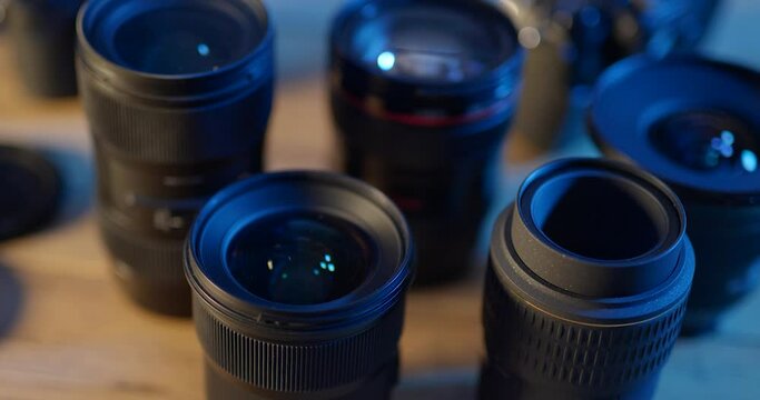 Assortment of DSLR camera lenses on desk in photographic studio