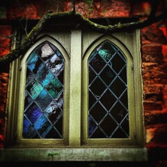 Stained Glass Windows in Old Stone Church with Branch
