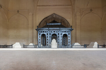 Vijayapura, Karnataka, India - November 8, 2013: Gol Gambaz Mausoleum. White tomgs lined up inside under dome. Black bluish baldachin above main grave. © Klodien