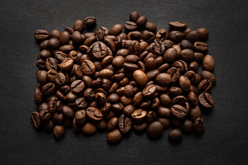 Rectangle made of roasted coffee beans on dark background