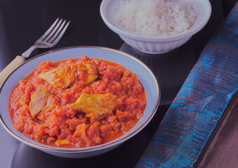 Traditional chicken madras with a bowl of rice.