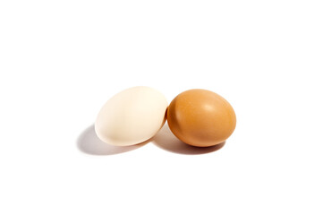 Two chicken eggs of different colors on a white background.