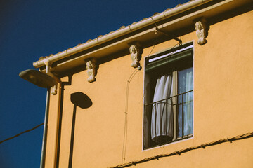 Fototapeta na wymiar Open window with curtain on a sunny day in Spain. Yellow house type Spanish - Italian - French. South European architecture.