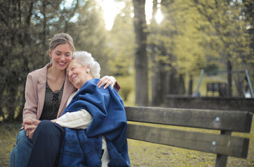 grandson with grandmother huddled in a park