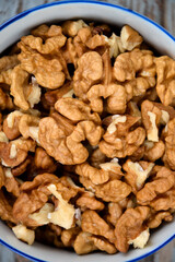 Walnuts. Walnut kernels. Clean organic walnuts. Nuts in the cup on vintage blue wooden background. Walnut tree fresh fall harvest.