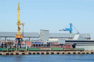 Lifting harbor cranes and railway wagons in the cargo seaport