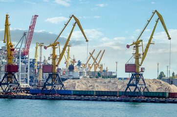 Lifting harbor cranes and railway wagons in the cargo seaport