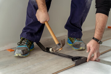 close up shot of a man worker fitting laminate flooring