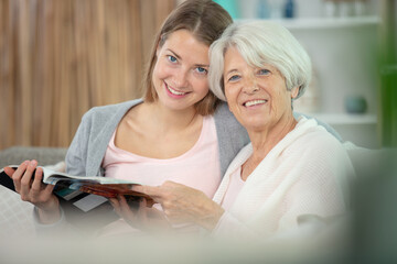 senior woman with daughter reading magazine together