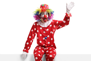 Clown sitting on a white panel and waving