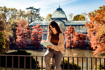Woman reading a book sitting on a fence